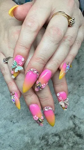 Pink and yellow ombre nails with charms and rhinestones