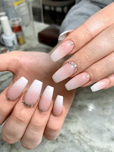 Soft nude to white ombre coffin nails with crystal detail